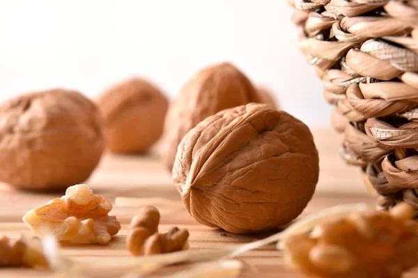 Macro Detail Walnuts Wooden Table Pieces Fruit Next Wicker Basket — Stock Photo, Image