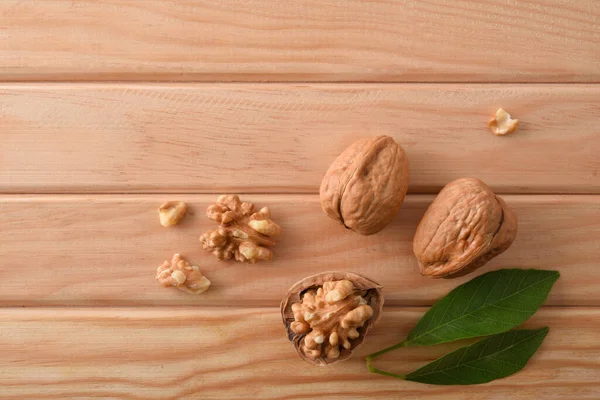 Detailní Vlašské Ořechy Ulomenou Skořápkou Odhalující Semena Dřevěném Stole Listí — Stock fotografie