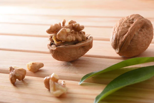 Detail Walnuts Wooden Table Broken Shell Pieces Leaves Elevated View — Stock Photo, Image