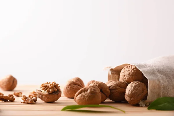 Group Walnuts Spilling Out Cloth Sack Seeds Leaves Wooden Table — Stock Photo, Image