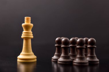 Güç ve kalabalığı kontrol etme ustalığı ve siyah masa ve arka planda satranç taşları olan erkekler arasında sınıflar