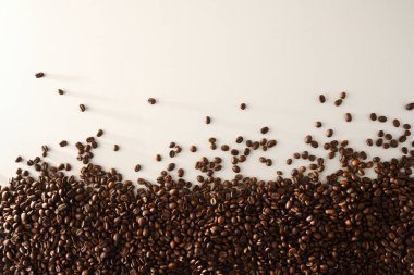 Doğal olarak kurutulmuş kahve çekirdekleri bir tarafta beyaz masanın üzerinde. Üst Manzara. Yatay bileşim.