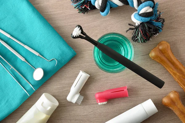 Ahşap masadaki köpek dişlerini temizlemek için profesyonel veteriner ürünleri ve aksesuarlar. Üst Manzara. Yatay bileşim.