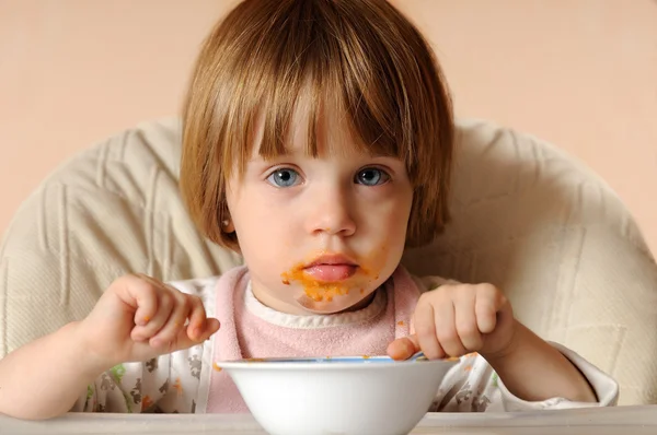 女の子は椅子に座ってスパゲッティを食べ終わってください。 — ストック写真