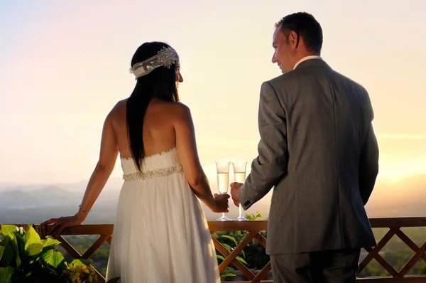 Groom and bride toasting on a terrace eye contact rear view — Stock Photo, Image