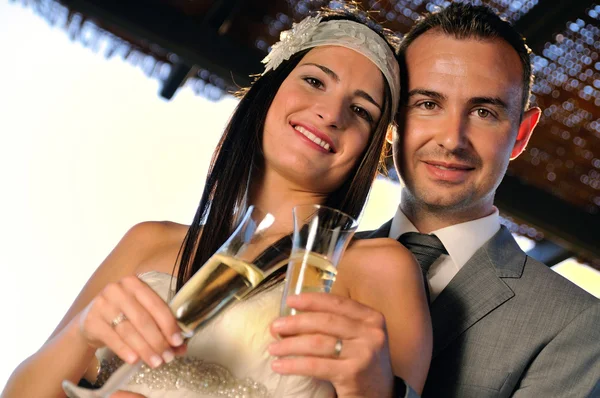 Groom and bride toasting smiling on a terrace looking ahead — Stock Photo, Image