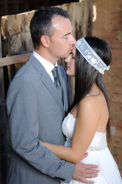 Groom giving gentle kiss on the forehead to the bride — Stock Photo, Image