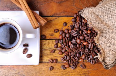 Kahve fincanı ve tahıl ahşap bir masa üzerinde olan torba