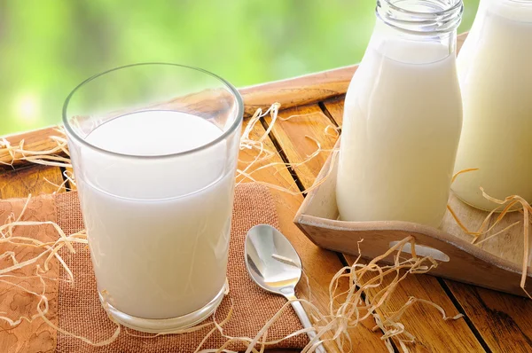 Glass of milk on a table on the field