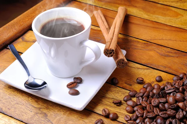 Kopp rykande kaffe på ett brunt bord — Stockfoto