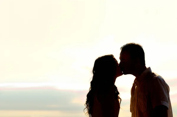 Couple kissing at sunset backlit — Stock Photo, Image