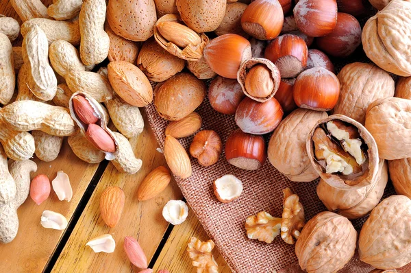 Tasty nuts on a wooden table in field top view Royalty Free Stock Images