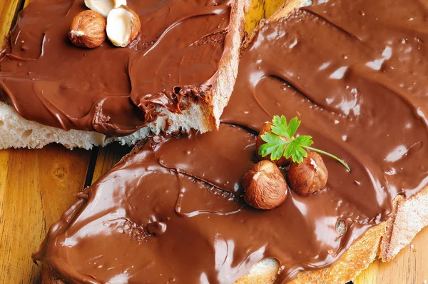 Brood met chocolade crème en hazelnoten op Close-up tafelblad — Stockfoto