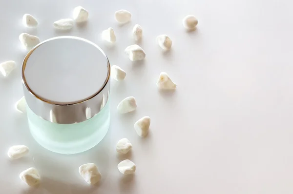 Tarro de crema cerrado sobre mesa de vidrio aislado — Foto de Stock