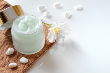 Krem kavanoz açık çuval bezi ile izole taşları yukarı