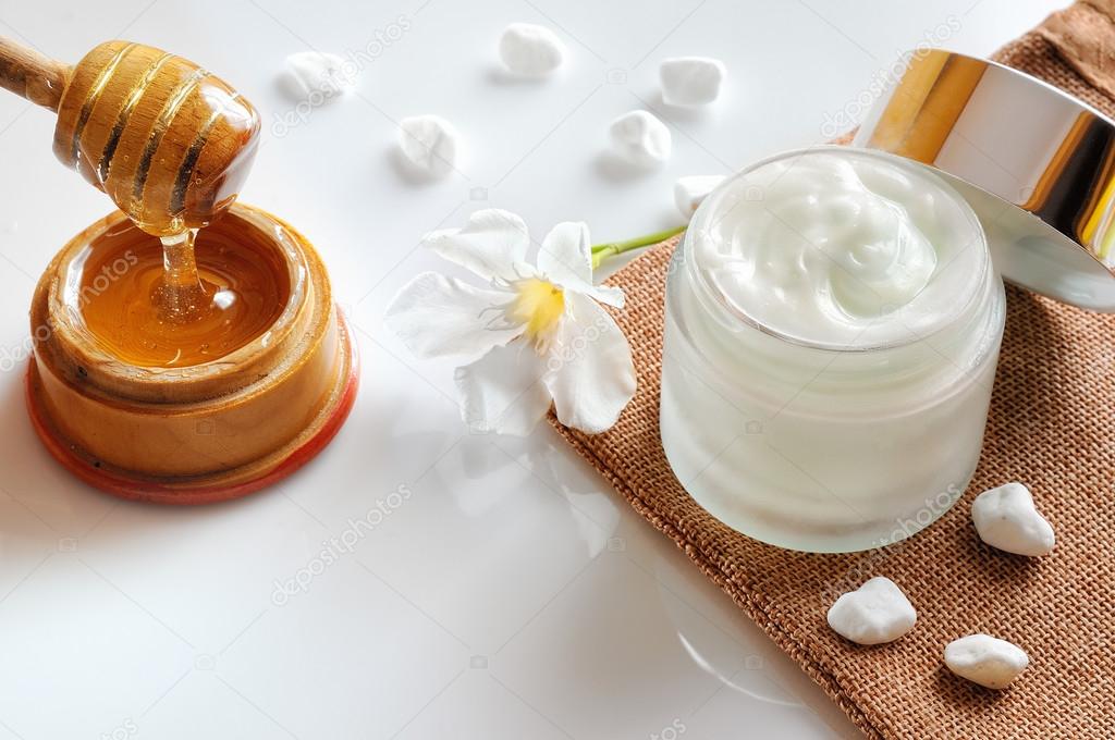 Honey moisturizer with stones and flower top view