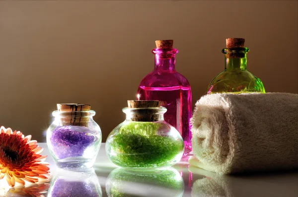 Oils and bath salts on white glass table dimly light — Stock fotografie