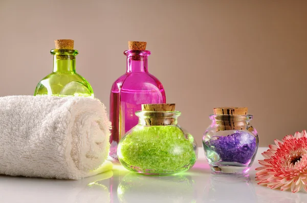 Oils and bath salts on white glass table — Stock Photo, Image