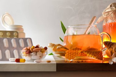 Comparison between traditional chemical medicine and alternative herbal medicine with capsules and pills for medication on white and natural medicinal products on wooden table. Front view.