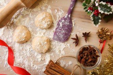 Ahşap mutfak tezgahı etrafa saçılmış un, alet edevat ve malzemelerle anason kurabiyeleri hazırlıyor. Üst görünüm