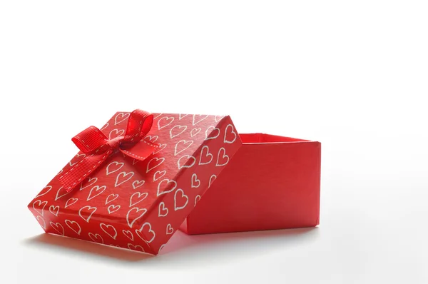 Открытый красный подарок с бантом и раскрашенными сердцами — стоковое фото