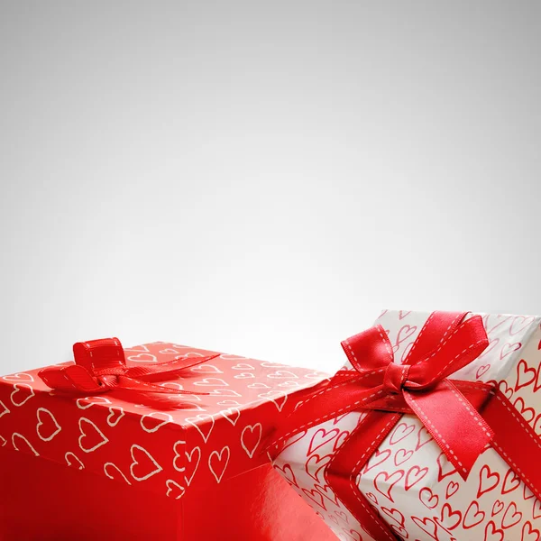 Zwei Geschenkboxen mit Herzen bedruckt mit grauem Hintergrund Nahaufnahme — Stockfoto