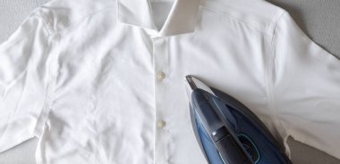 Steam ironing concept with an un-ironed, wrinkled shirt on one side and ironed on the other with a steam iron on top. Top view.