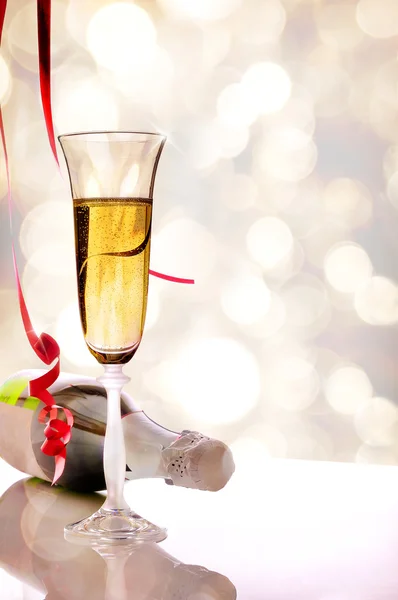 Glass of sparkling white wine and bottle on table vertical — Stock Photo, Image