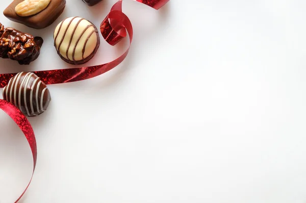 Bonbons sortidos com fita vermelha em uma mesa branca Top — Fotografia de Stock