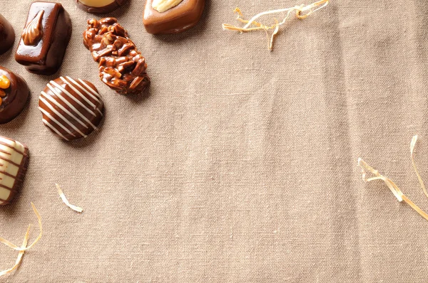 Assorted bonbons on tablecloth fabric with straw decoration top — Φωτογραφία Αρχείου