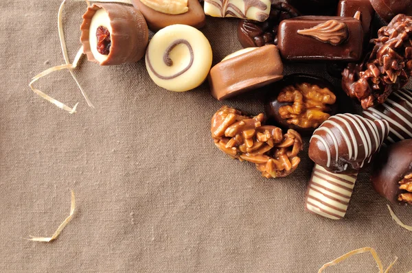 Group of bonbons stacked on tablecloth fabric with straw decorat — Stockfoto