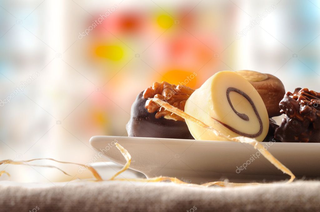 Assorted bonbons in white dish and colorfull background front vi