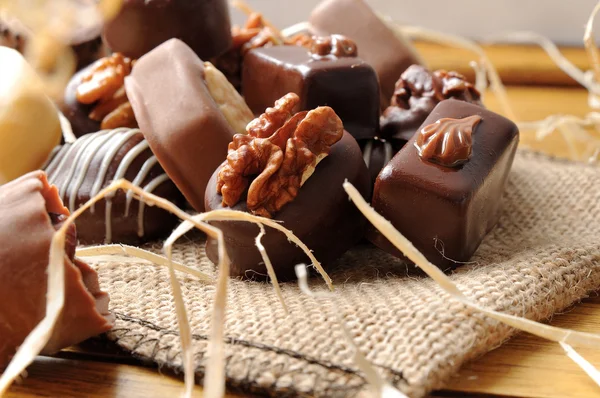 Close up bonbons empilhados em saco de serapilheira em mesa de madeira — Fotografia de Stock