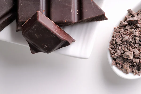 Chocolate chips and portions on containers close up top — Stockfoto