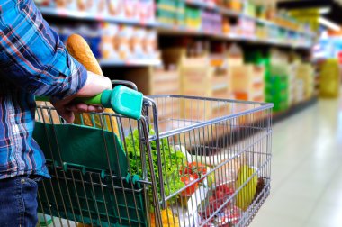 Alışveriş sepeti süpermarket koridorda iterek adam