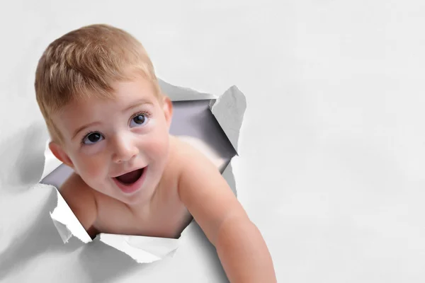Funny background of a baby coming out of a paper — Stock Photo, Image