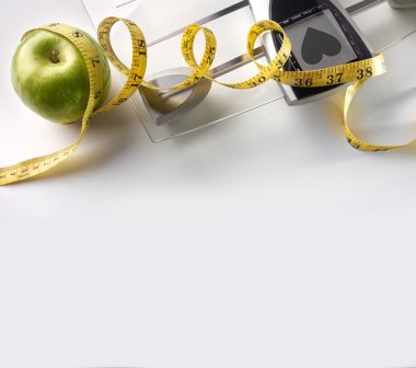 Heart scale with apple and tape measure square composition top