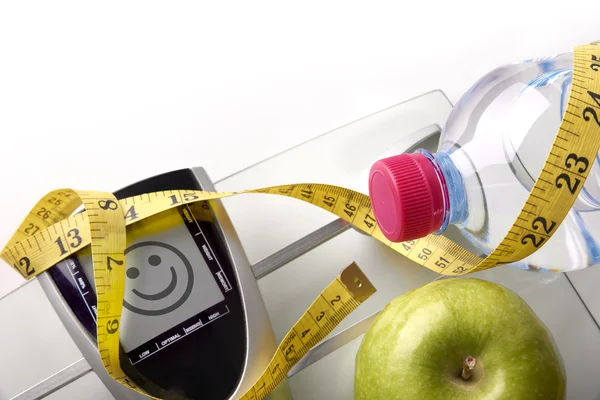 Face scale with bottle apple and tape measure top — Stock Photo, Image