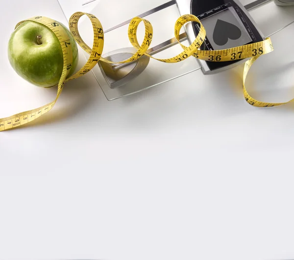 Heart scale with apple and tape measure square composition top — Stock Photo, Image