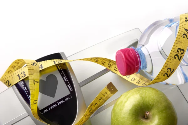 Heart scale with bottle apple and tape measure top — Zdjęcie stockowe