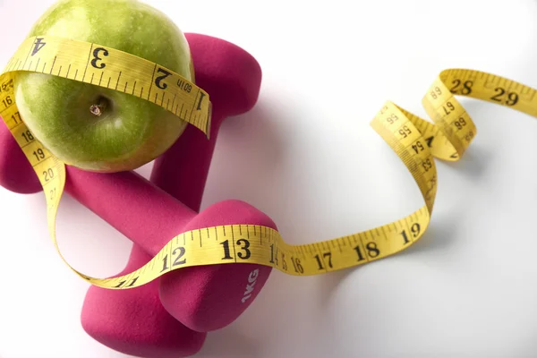 Pink dumbbells with apple and tape measure top — Zdjęcie stockowe