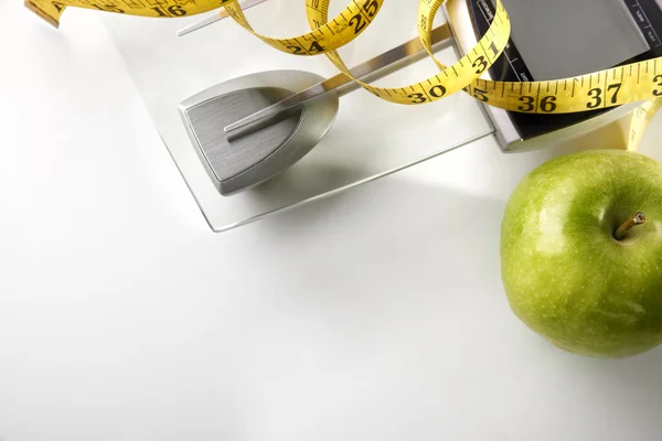 Scale with apple and tape measure horizontal composition top — Zdjęcie stockowe