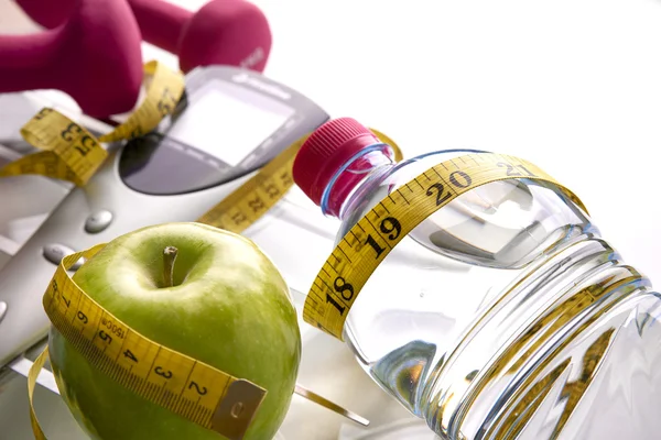 Scale with dumbbells bottle apple and tape measure elevated view — Stock fotografie