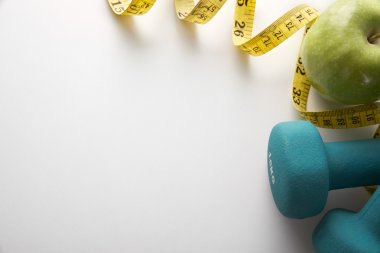 Green dumbbells with apple and tape measure top
