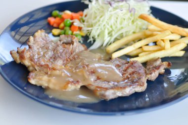 Biftek, patates kızartması ve salata.