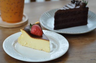 Bask peynirli kek, yanmış peynirli kek, çilekli sos ve çikolatalı pasta.