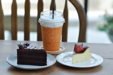 Bask peynirli kek, çilekli yanmış cheesecake, çikolatalı kek ve sütlü çay.