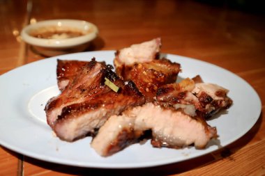 Izgara domuz eti, domuz bifteği veya dilimlenmiş domuz eti ve sos.