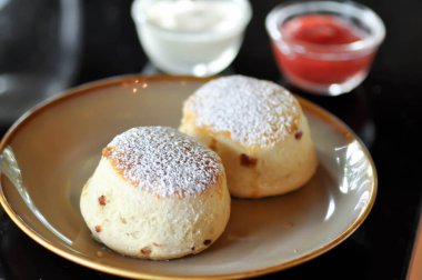 Çörek, çilek soslu çörek ve krema.