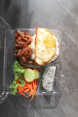 fried pork or stir fried pork with fruit and rice in the box